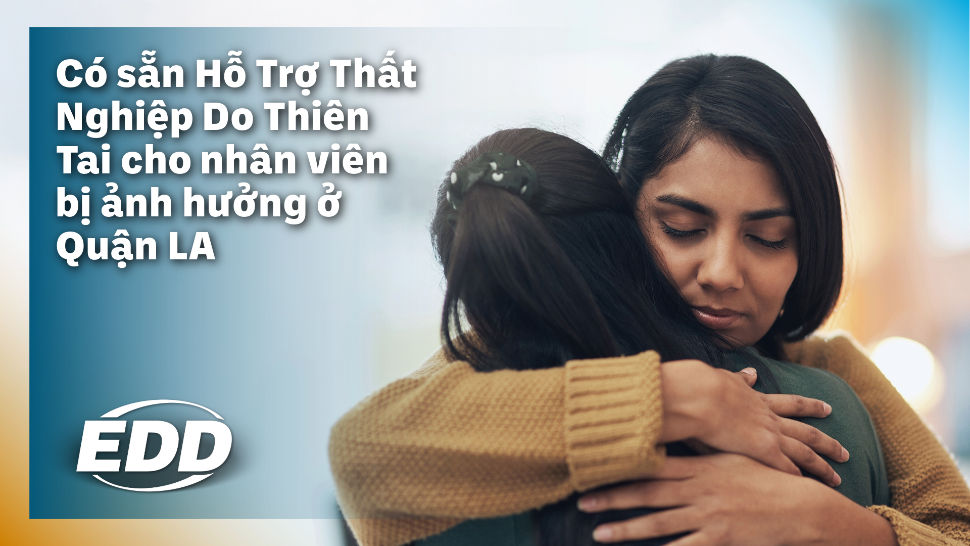 Hai người đang ôm và an ủi nhau, trên nền hình ảnh mờ phía sau, có dòng chữ: 'Có sẵn Hỗ Trợ Thất Nghiệp Do Thiên Tai cho nhân viên bị ảnh hưởng ở Quận LA.